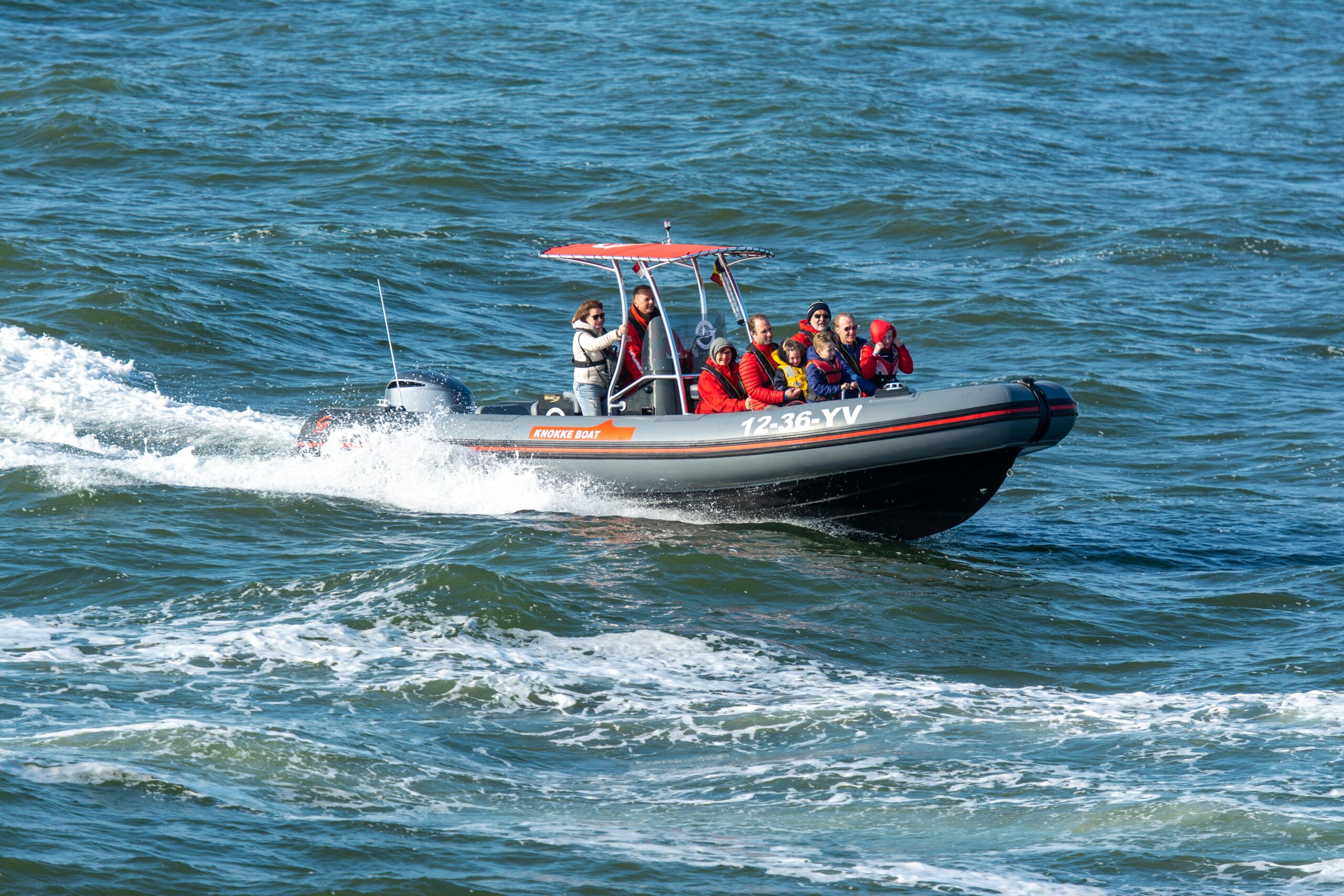 Group of tourists having an adventure ride in an inflatable boat on a sunny day.