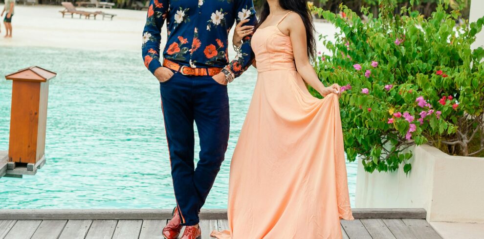 Couple enjoying a stylish photoshoot on a dock in the Maldives, showcasing resort fashion and romantic vibes.