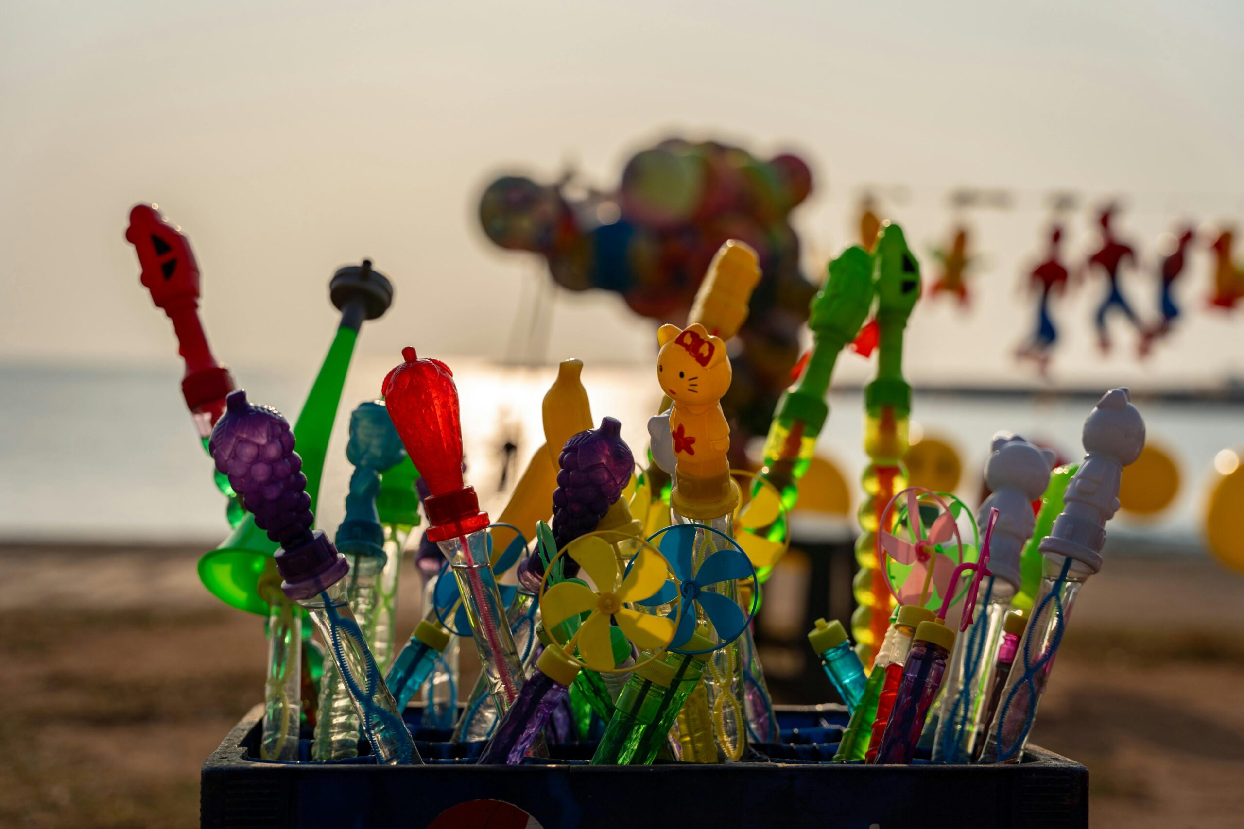 Vibrant children's toys displayed at the beach with a sunset backdrop in Colombo, Sri Lanka.