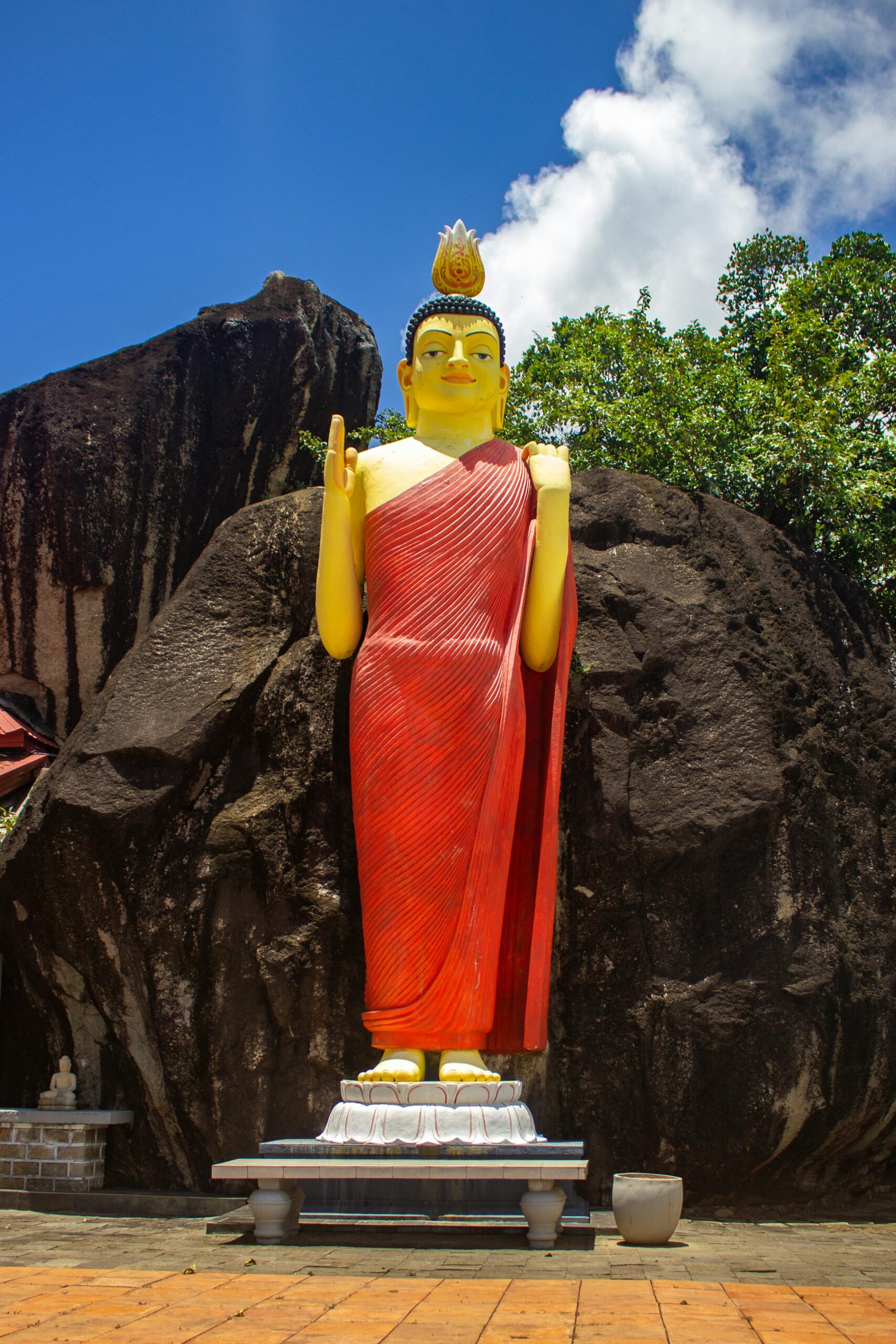Striking Buddha statue against rocky backdrop in Unawatuna, Sri Lanka.