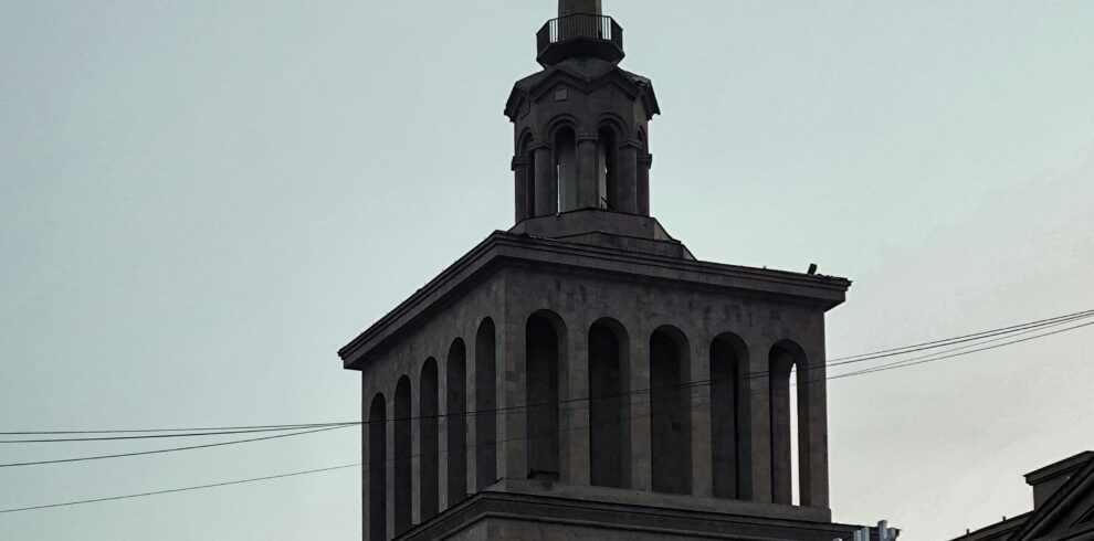 The iconic spire of Yerevan Train Station in Armenia captured during sunset.