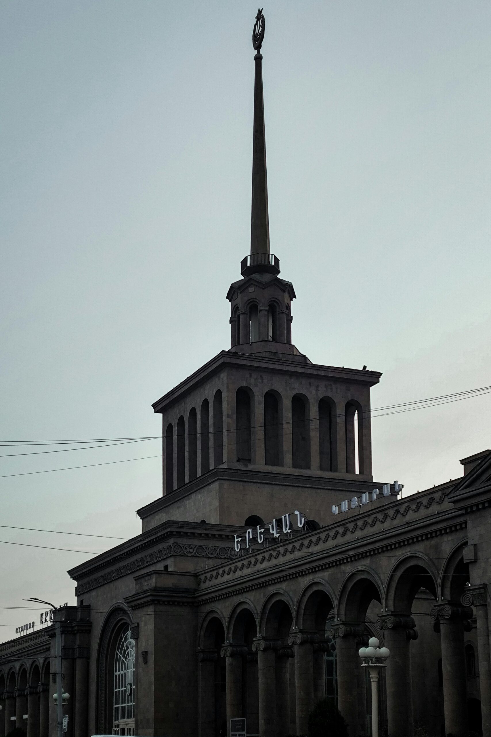 The iconic spire of Yerevan Train Station in Armenia captured during sunset.