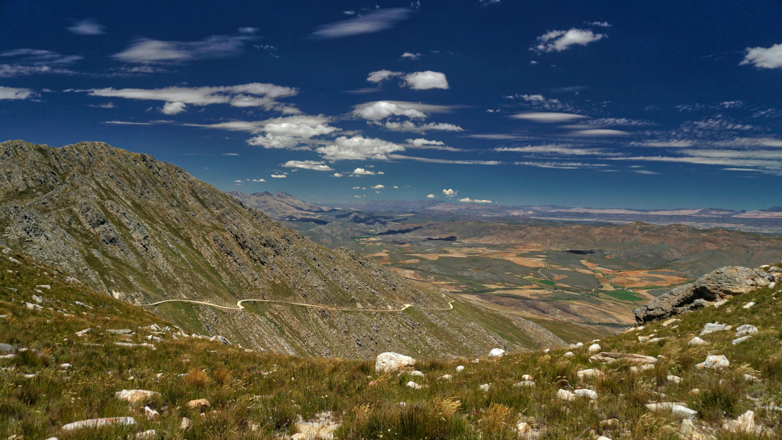 Expansive view of mountains and valley in Oudtshoorn, South Africa under a clear blue sky.