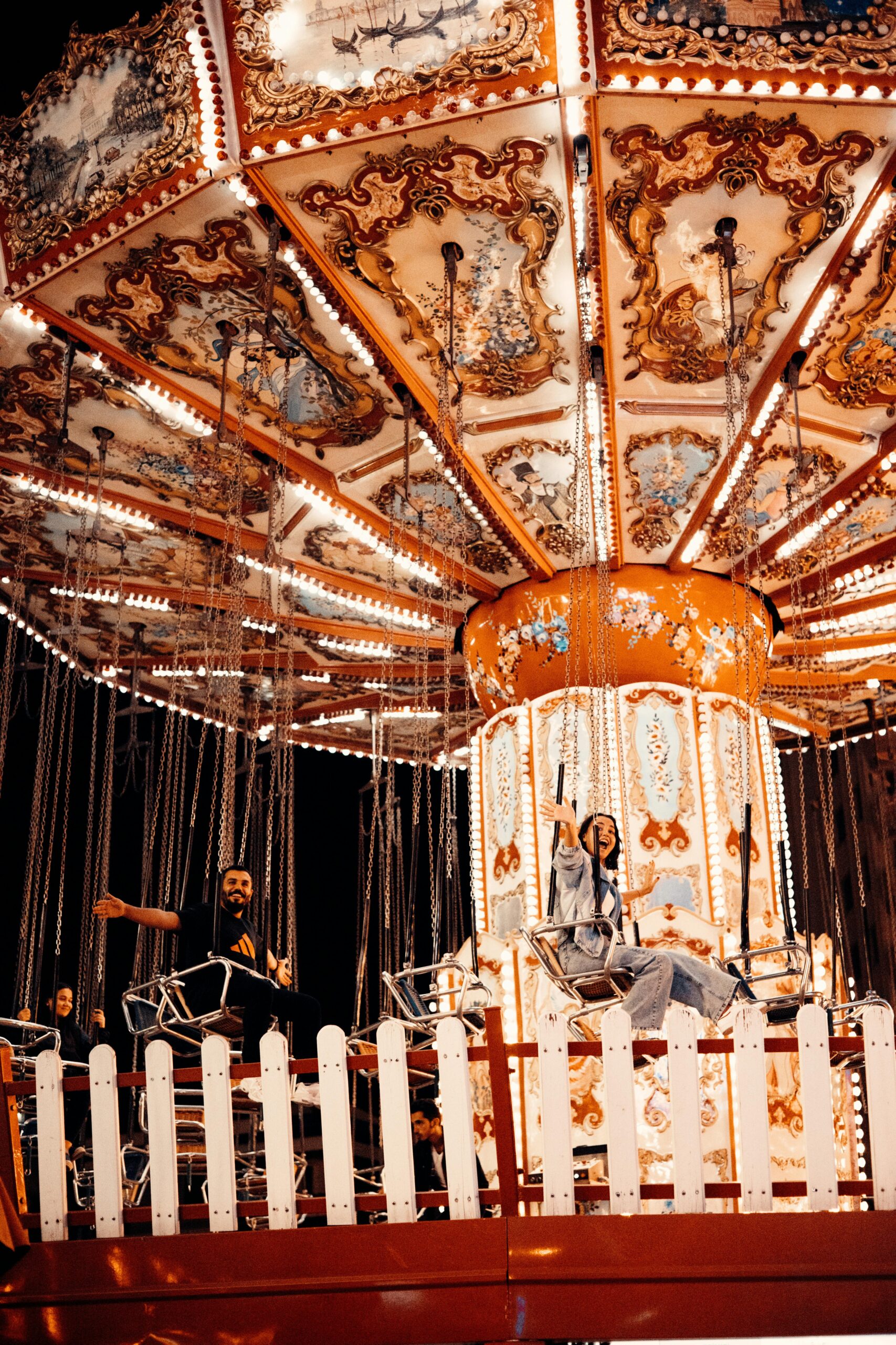 A vivid nighttime shot of a vintage carousel ride at an amusement park, capturing the fun and excitement.