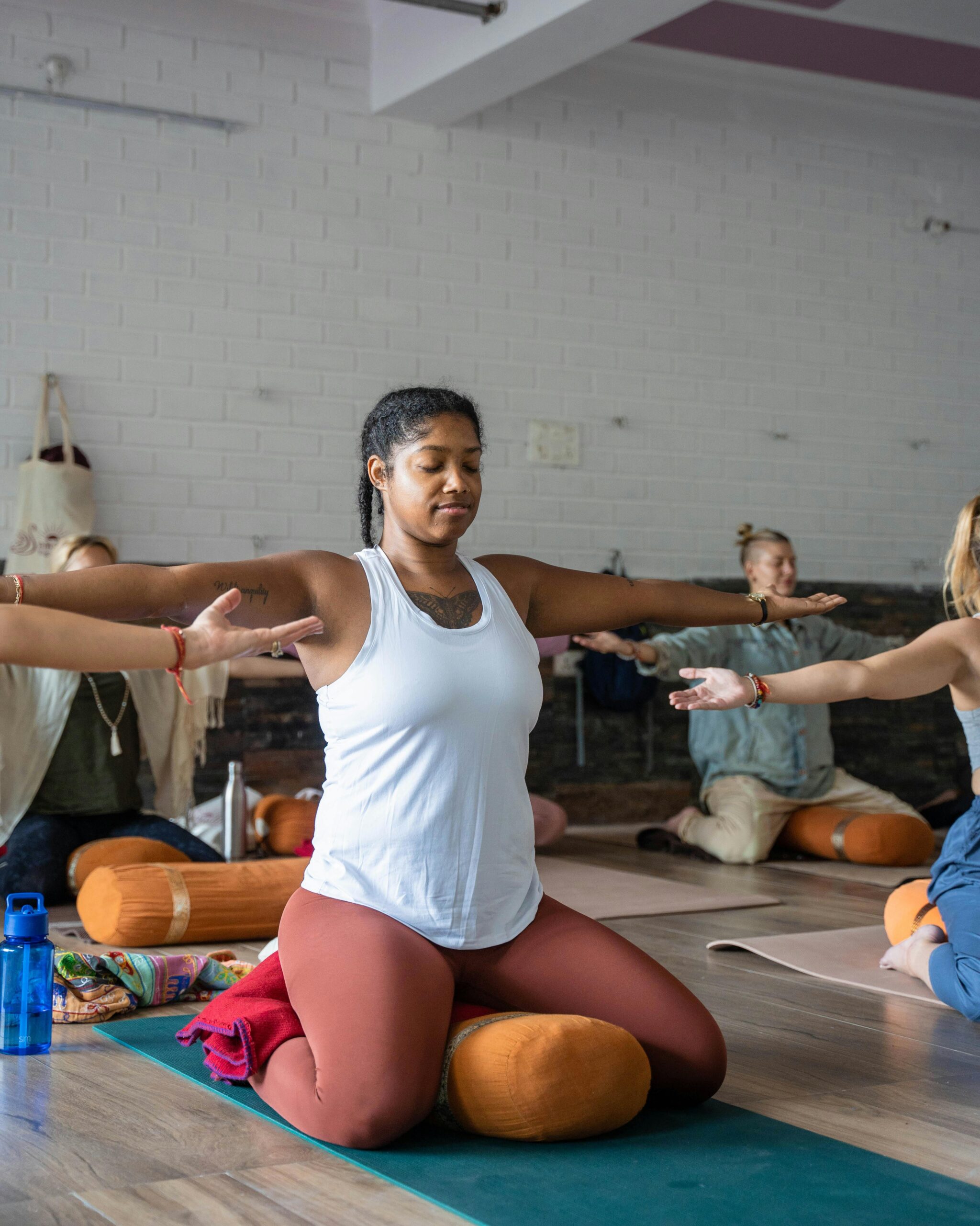 A calming yoga class with diverse participants practicing indoors in Rishikesh, India.