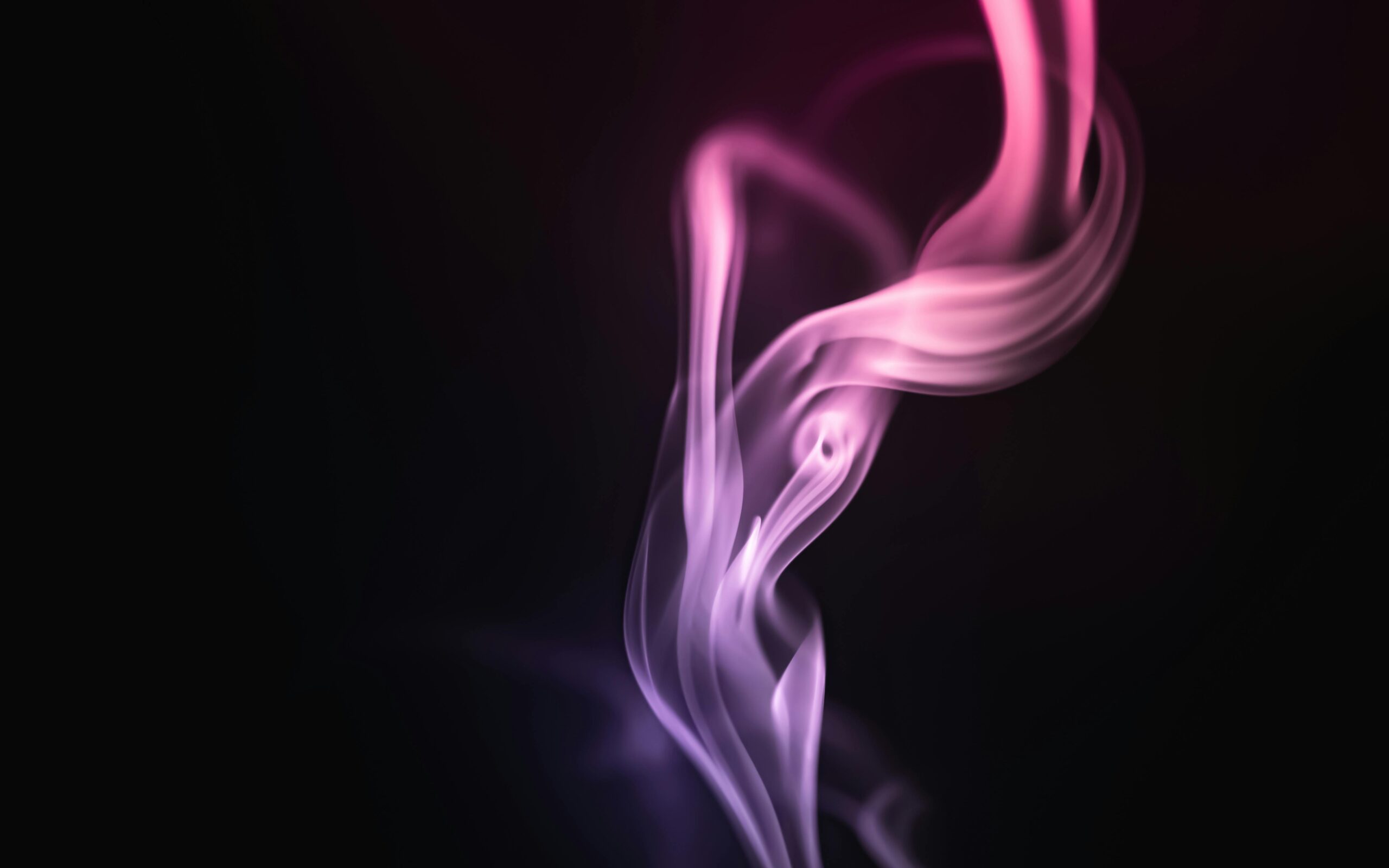 Mesmerizing pink and purple smoke against a dark background, creating an artistic and abstract visual.
