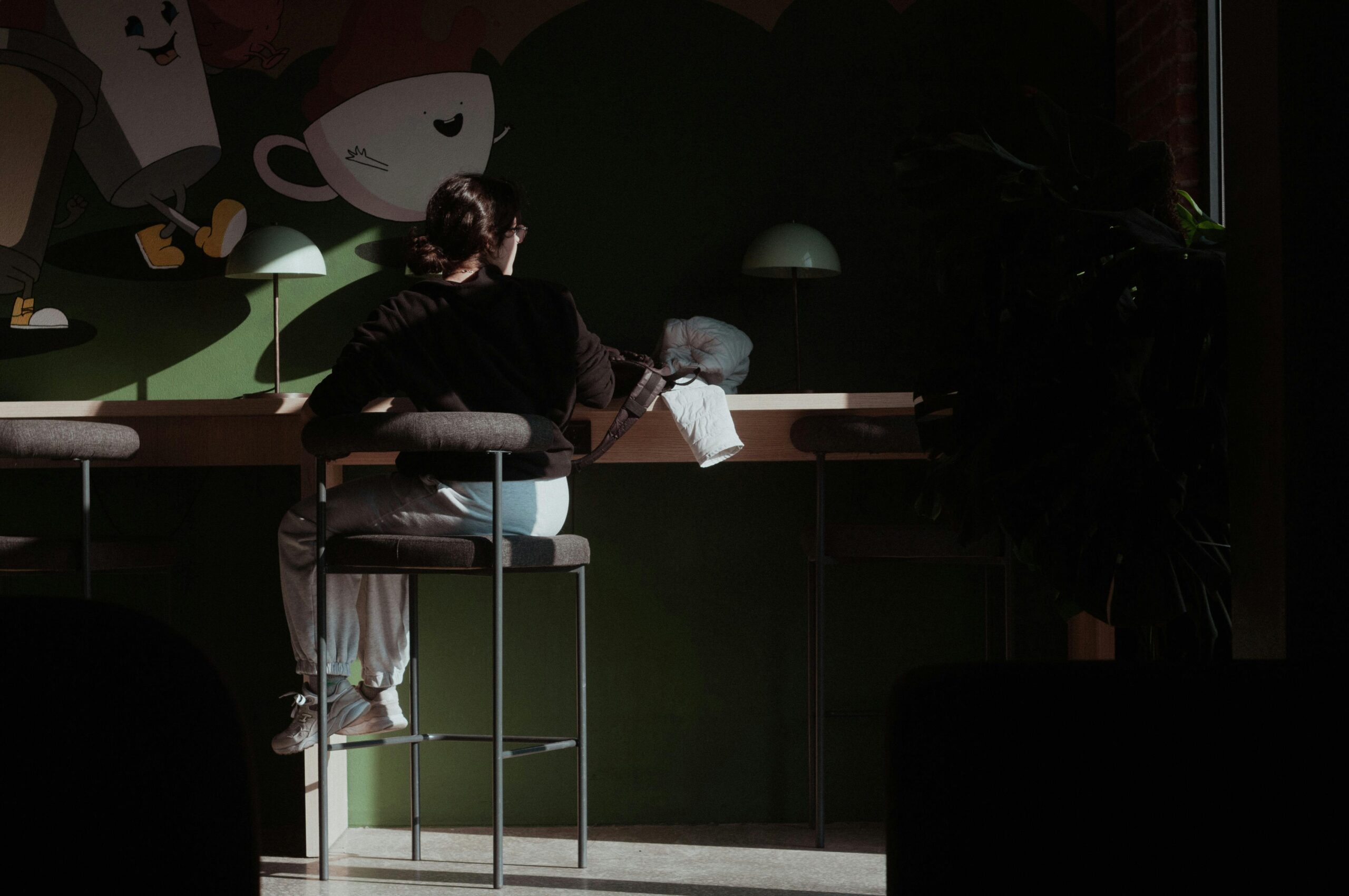 A person enjoys a quiet moment in an Istanbul café, surrounded by warm light.