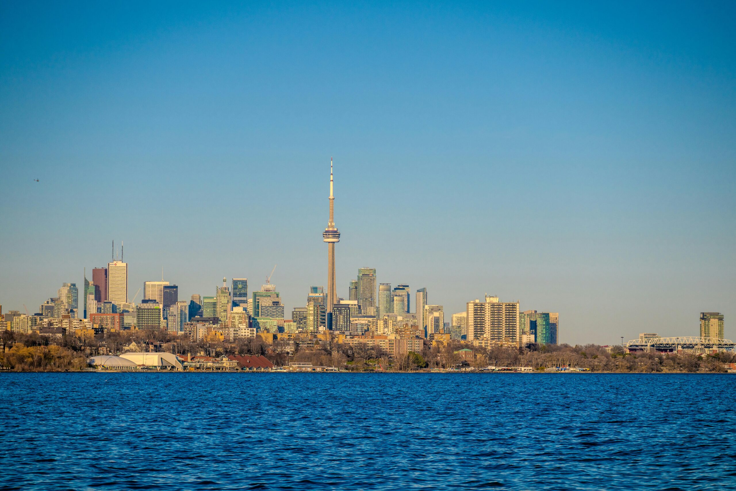 A breathtaking view of the Toronto skyline featuring the iconic CN Tower under a clear blue sky.
