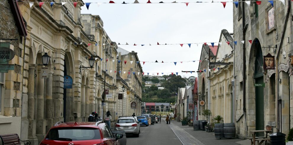 Charming view of a historic street in Oamaru, New Zealand, featuring architectural charm and bunting decoration.