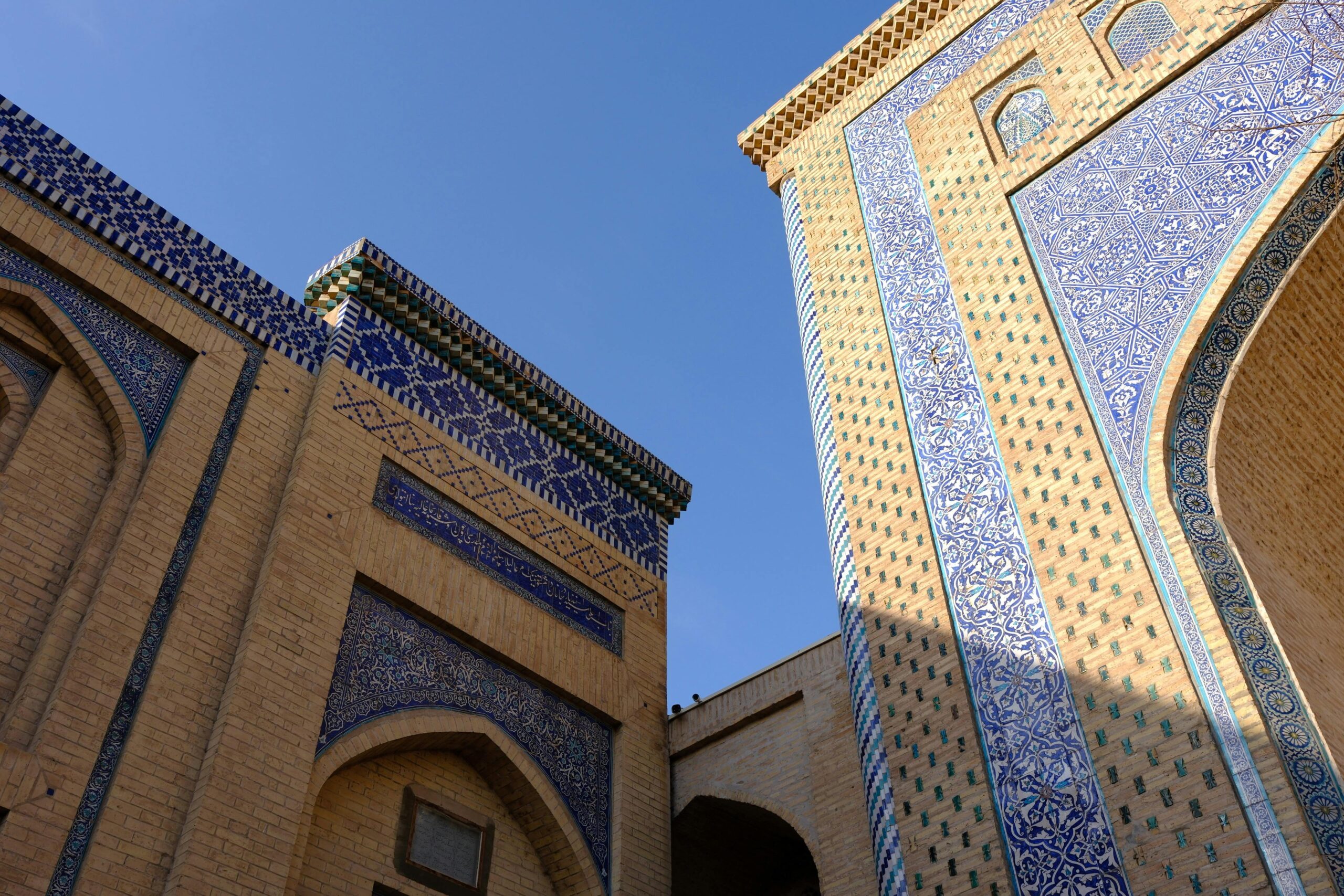 Stunning architecture featuring intricate blue tile designs on an Islamic building under a clear blue sky.