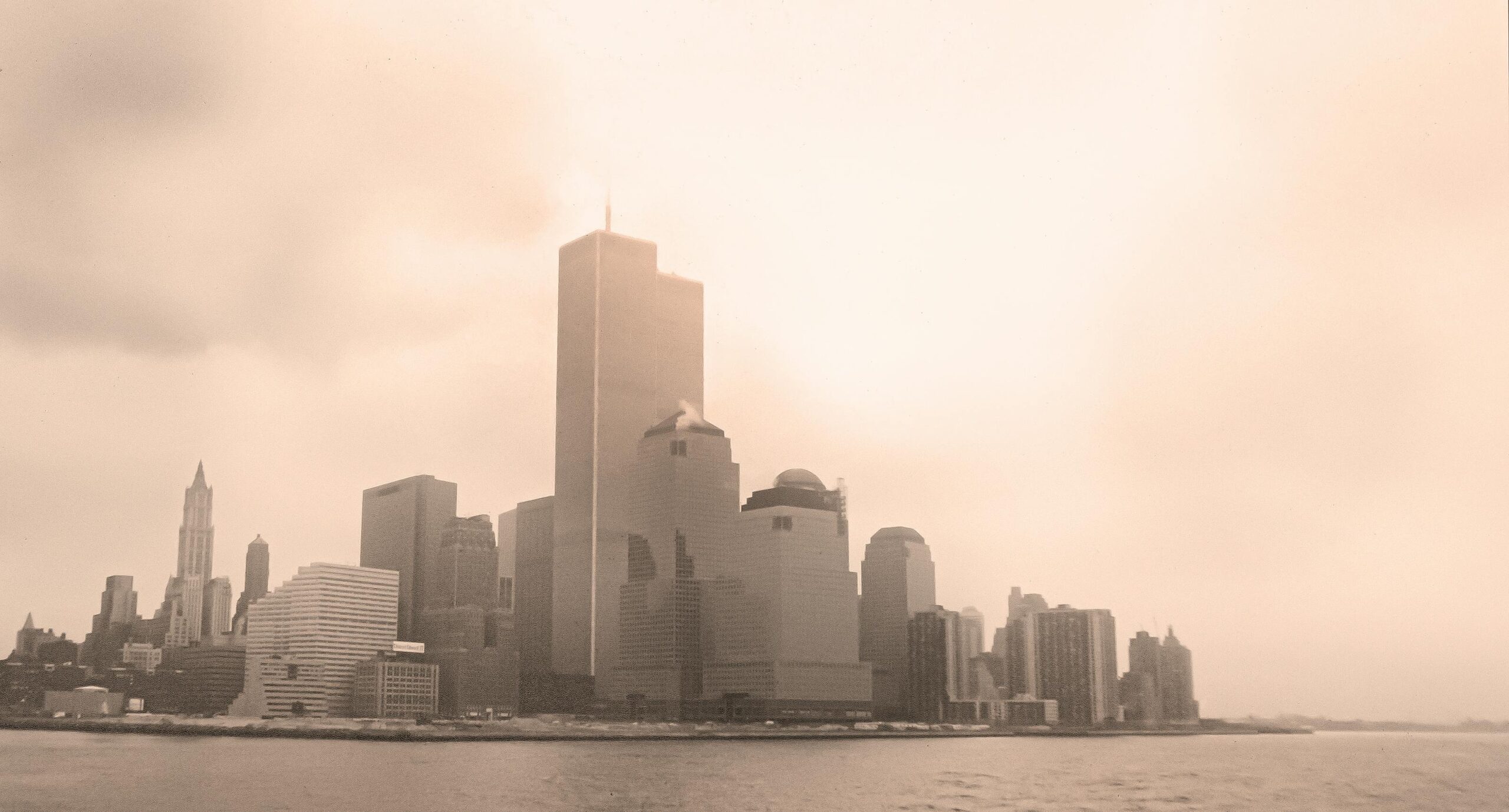 Sepia-toned view of New York City skyline with the Twin Towers on a foggy day.