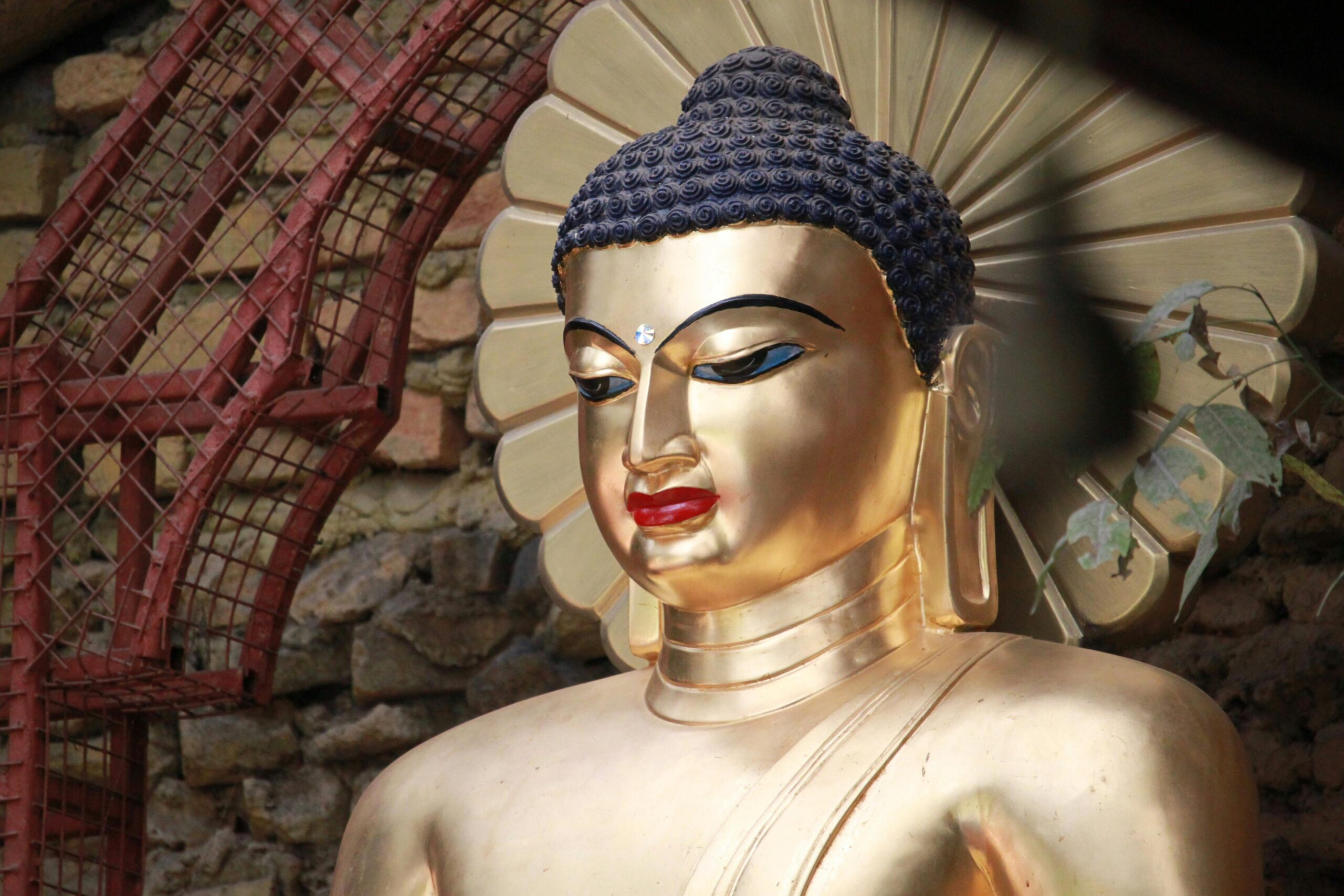 Close-up of a golden Buddha sculpture in Gaya, India with a serene expression.