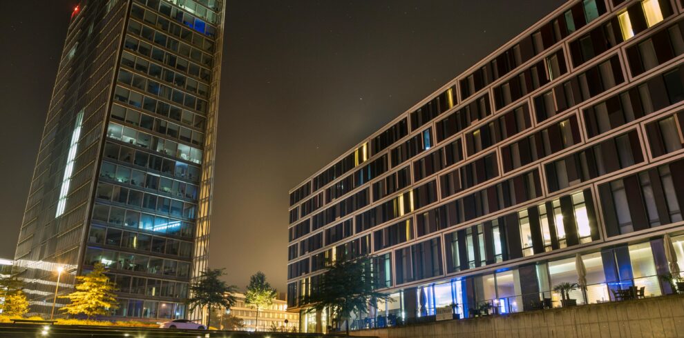A stunning view of modern buildings illuminated at night with a starry sky backdrop.