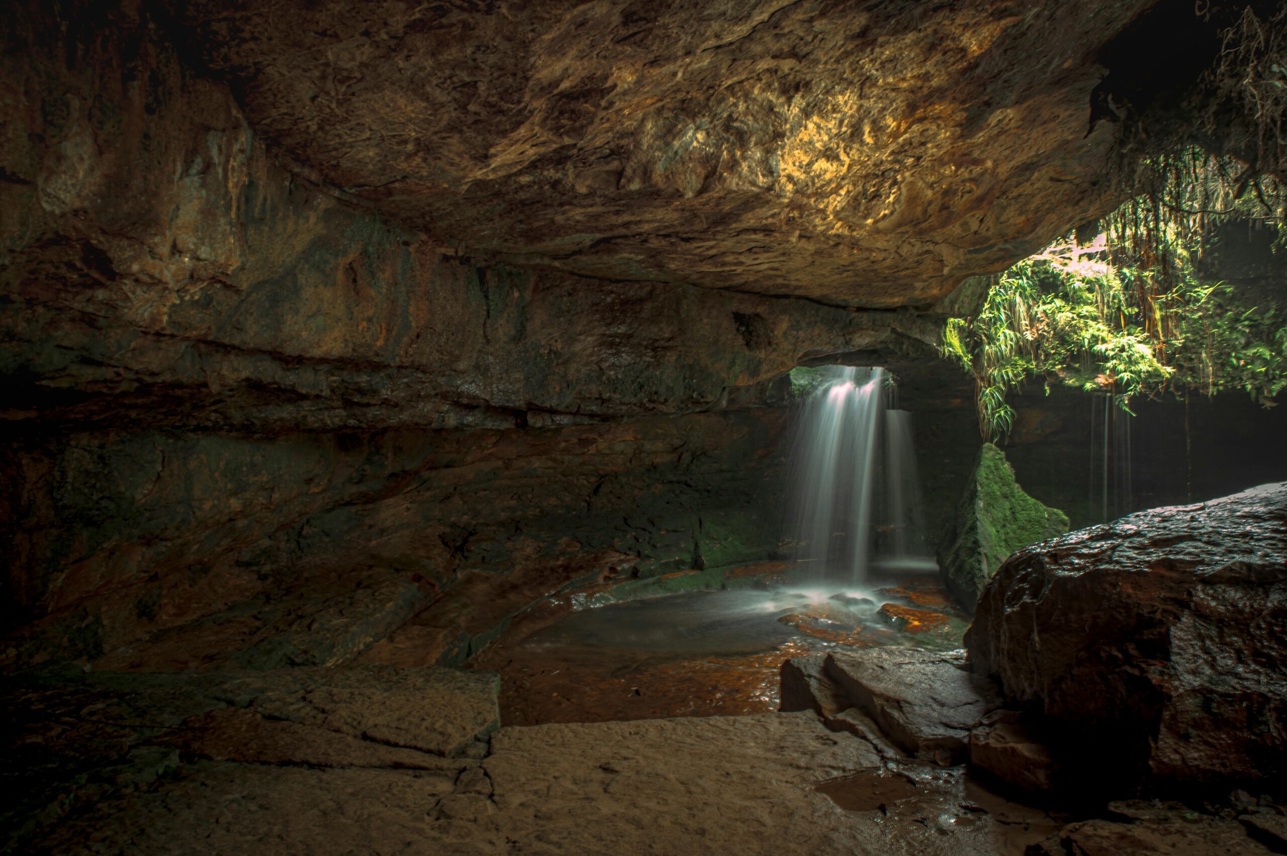 Serene waterfall cascading inside a natural cave in ML, India, offering a tranquil environment.