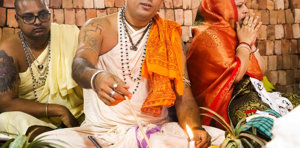 Priests performing a Hindu ritual in Dhaka, showcasing vibrant cultural traditions.