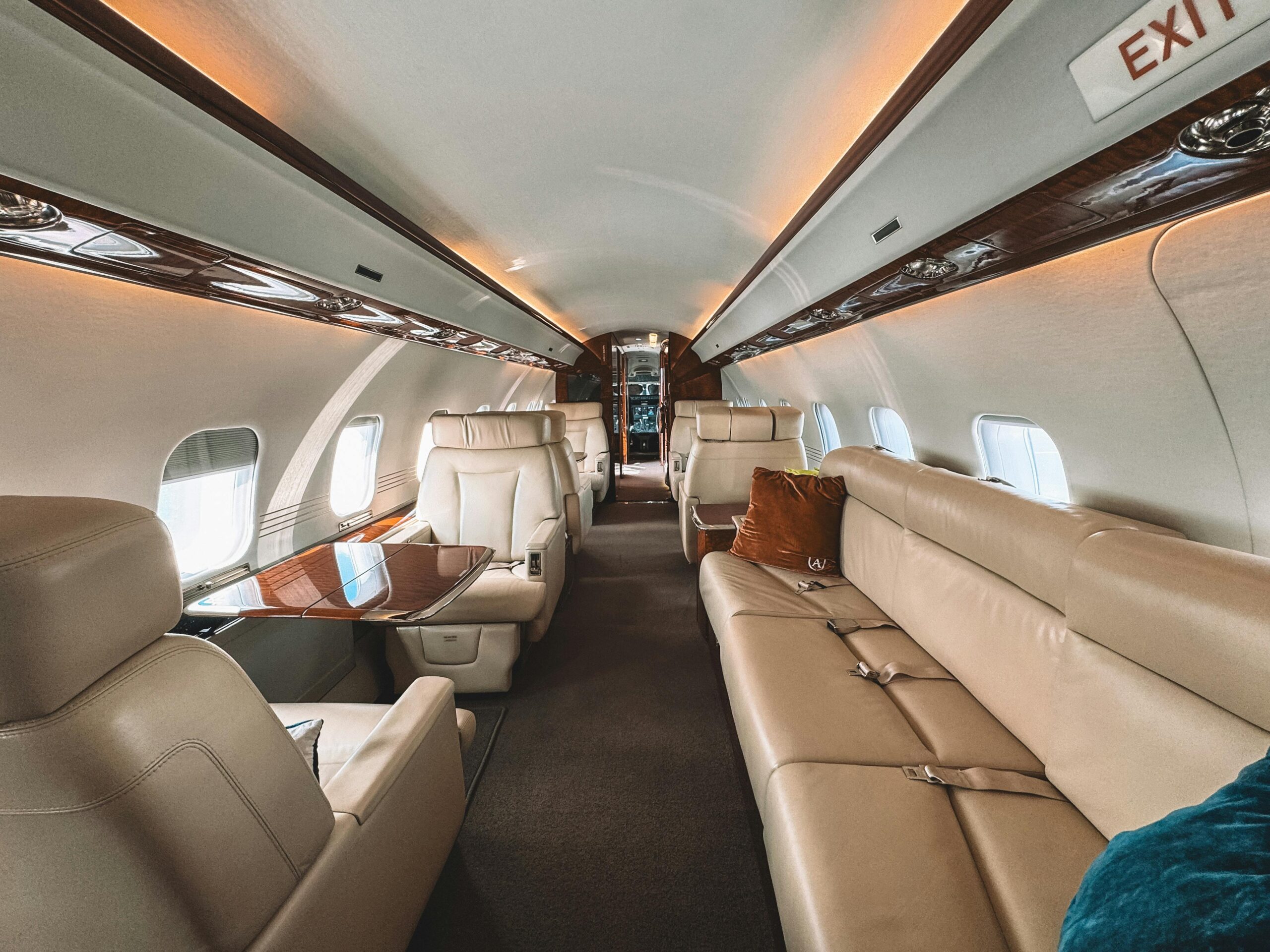 Explore the luxury of a private jet interior featuring leather seats and wooden trim, perfect for exclusive travel.
