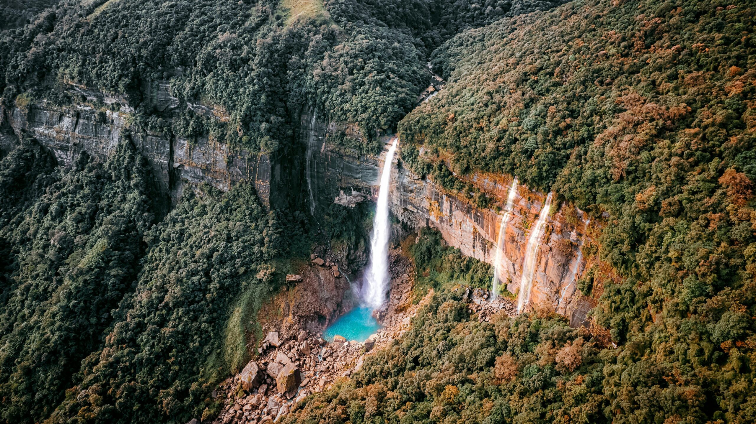 A stunning waterfall cascades in Meghalaya's jungle, offering a serene travel destination.