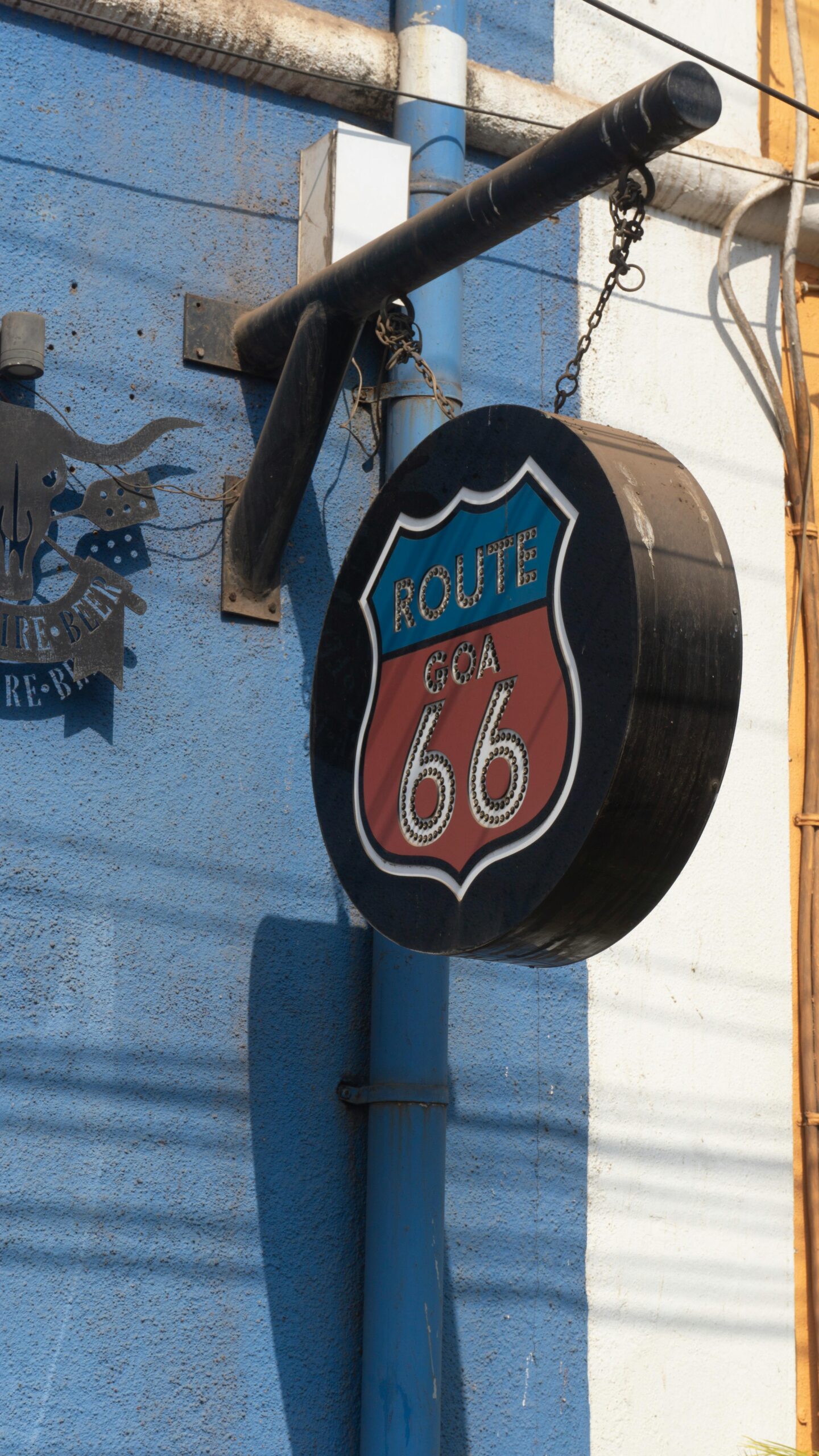 A classic Route 66 sign hanging on a colorful wall in sunny Goa, India.
