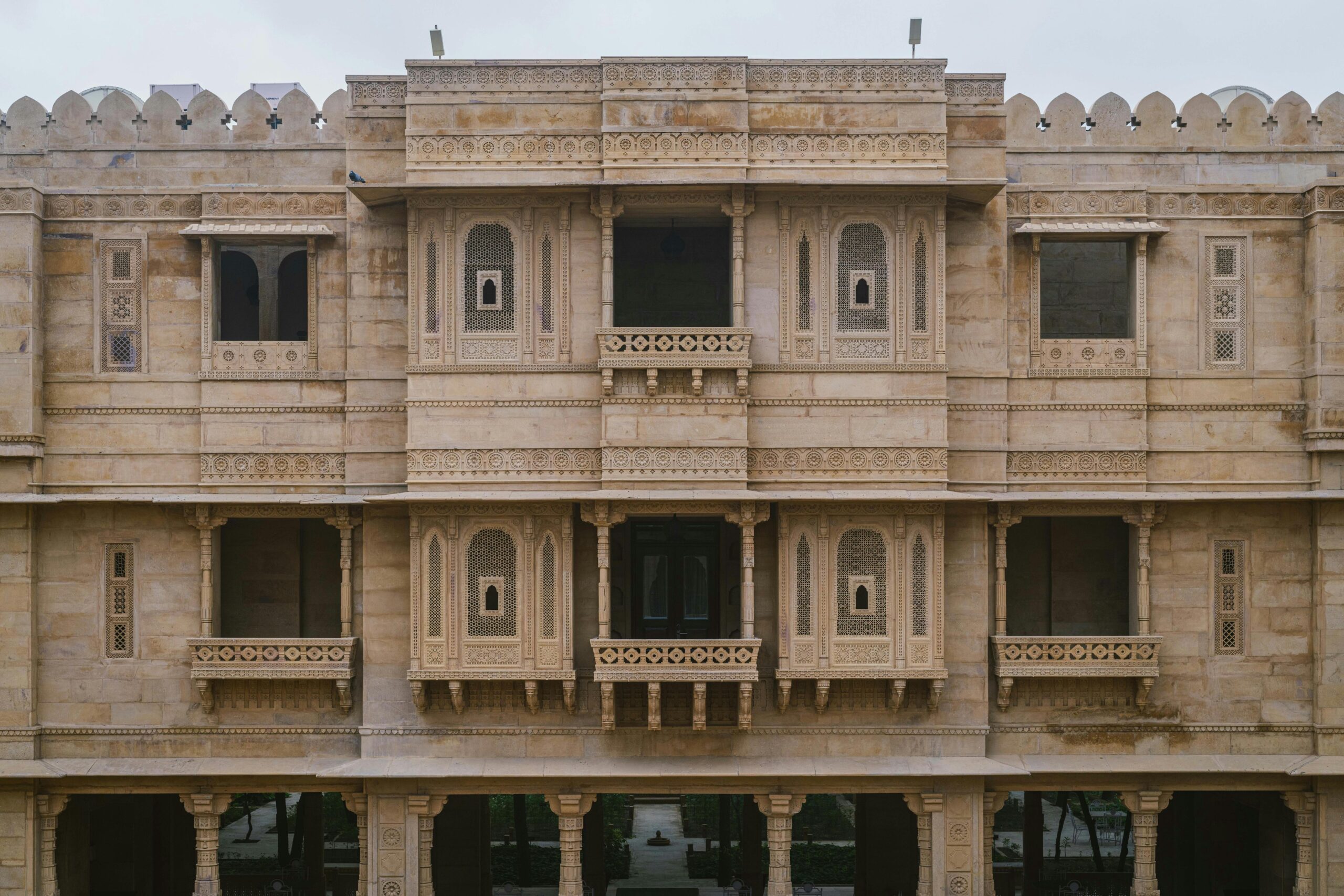 Impressive stone facade of a palace hotel in Jaisalmer, showcasing intricate architectural details.