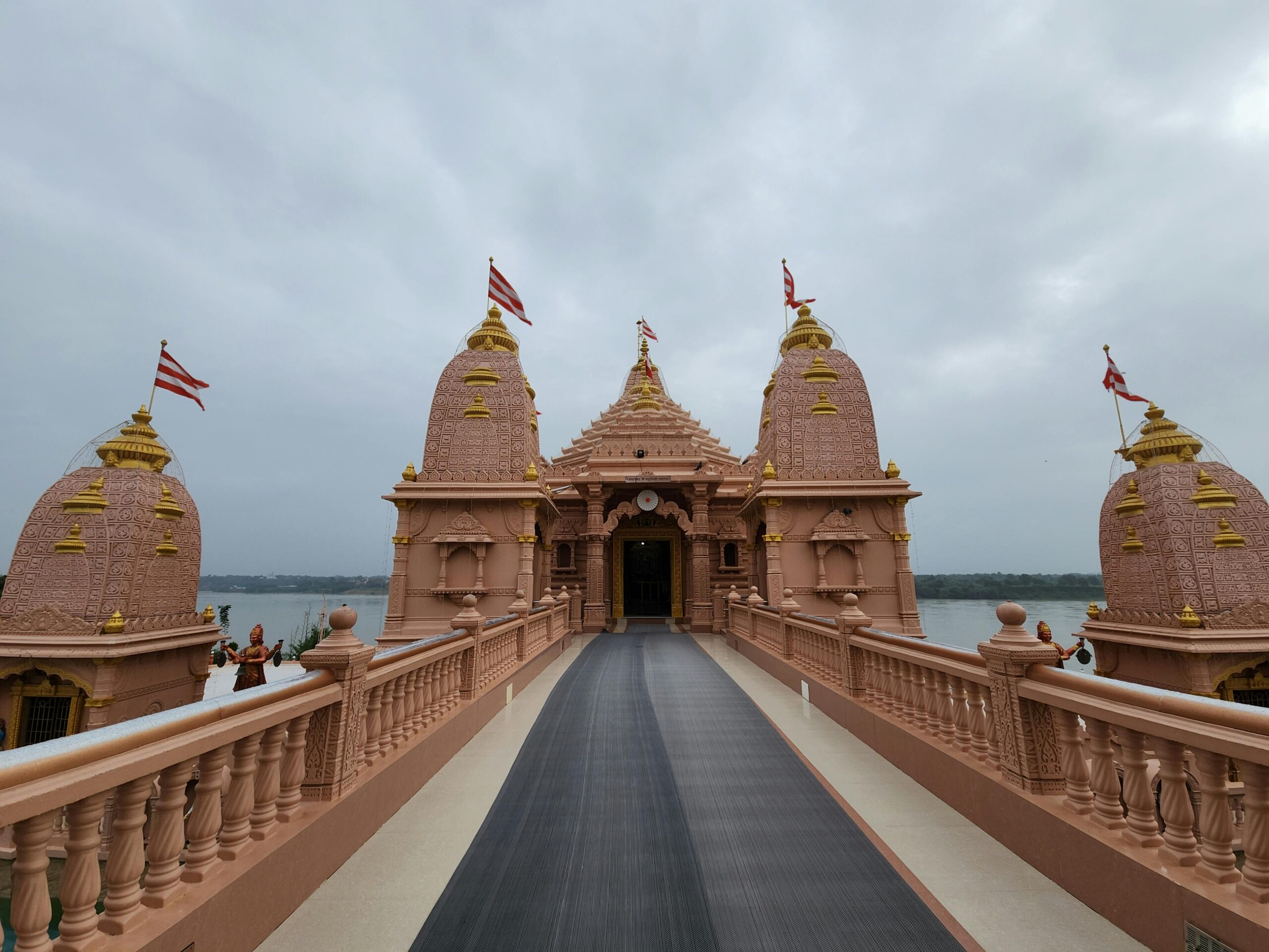 Beautiful temple with intricate architecture and flags on a cloudy day representing cultural heritage.
