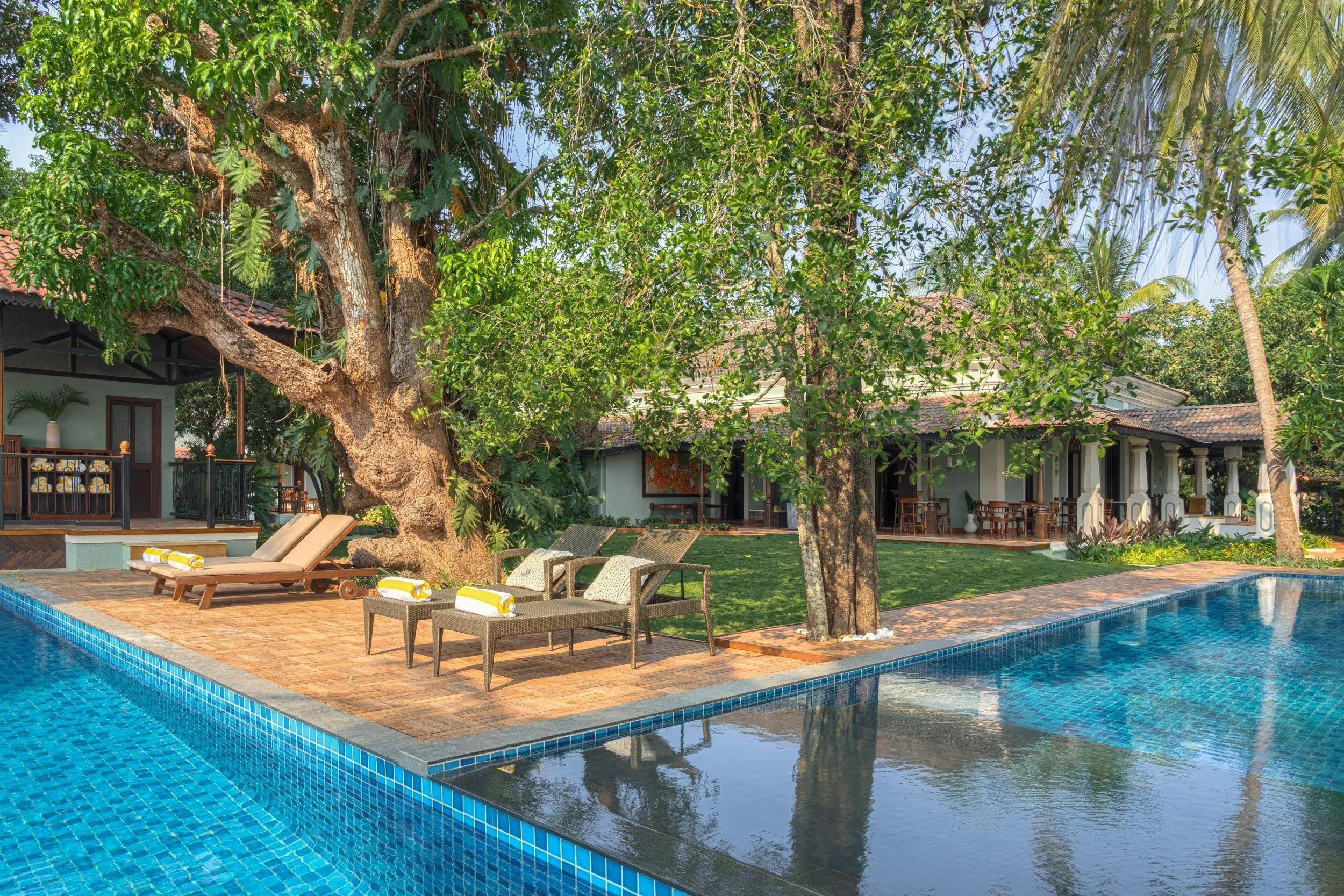Elegant villa with pool surrounded by lush greenery in Arpora, Goa, India.