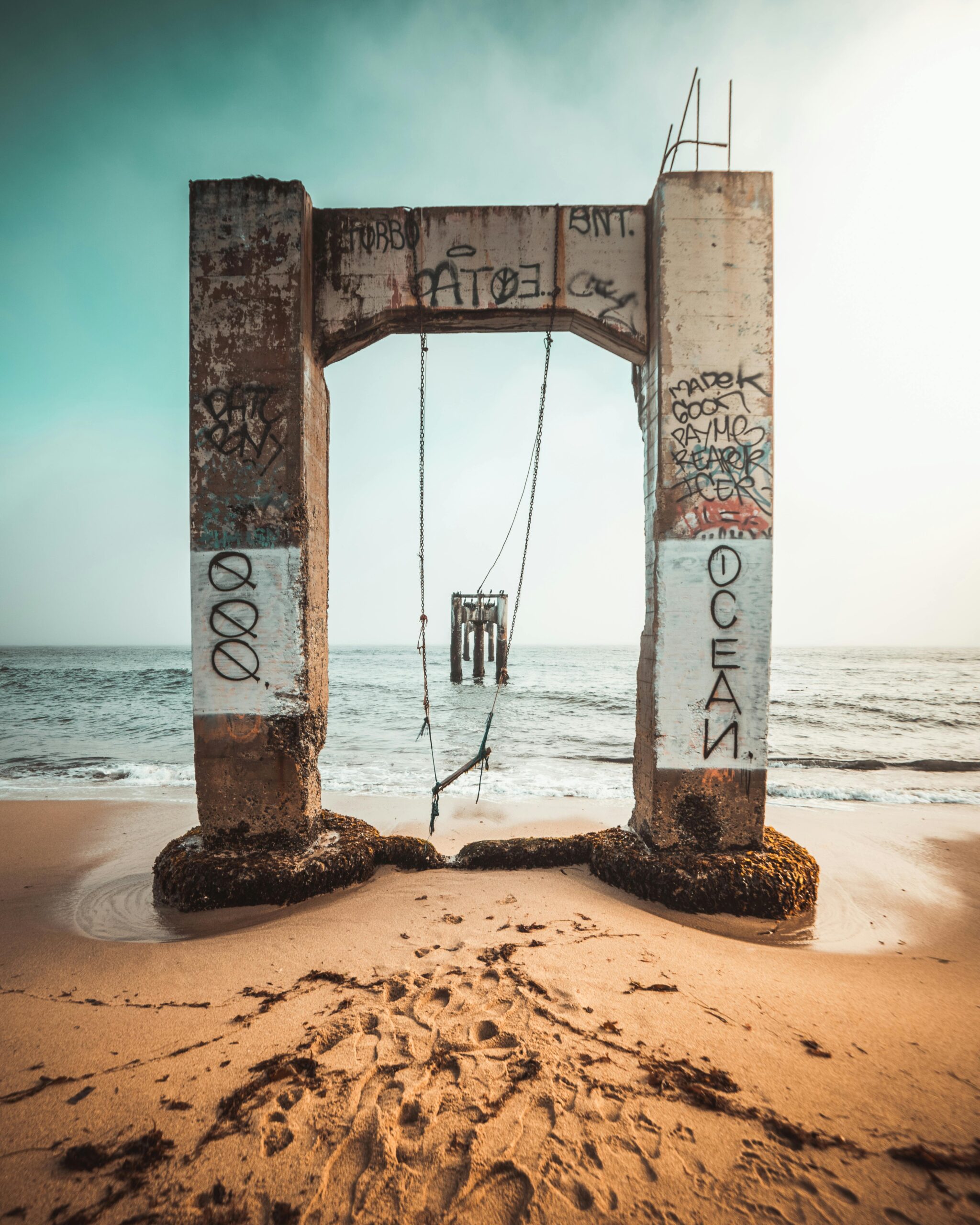 Explore the eerie beauty of a rusted swing set on an abandoned structure at the beach in Davenport, CA.