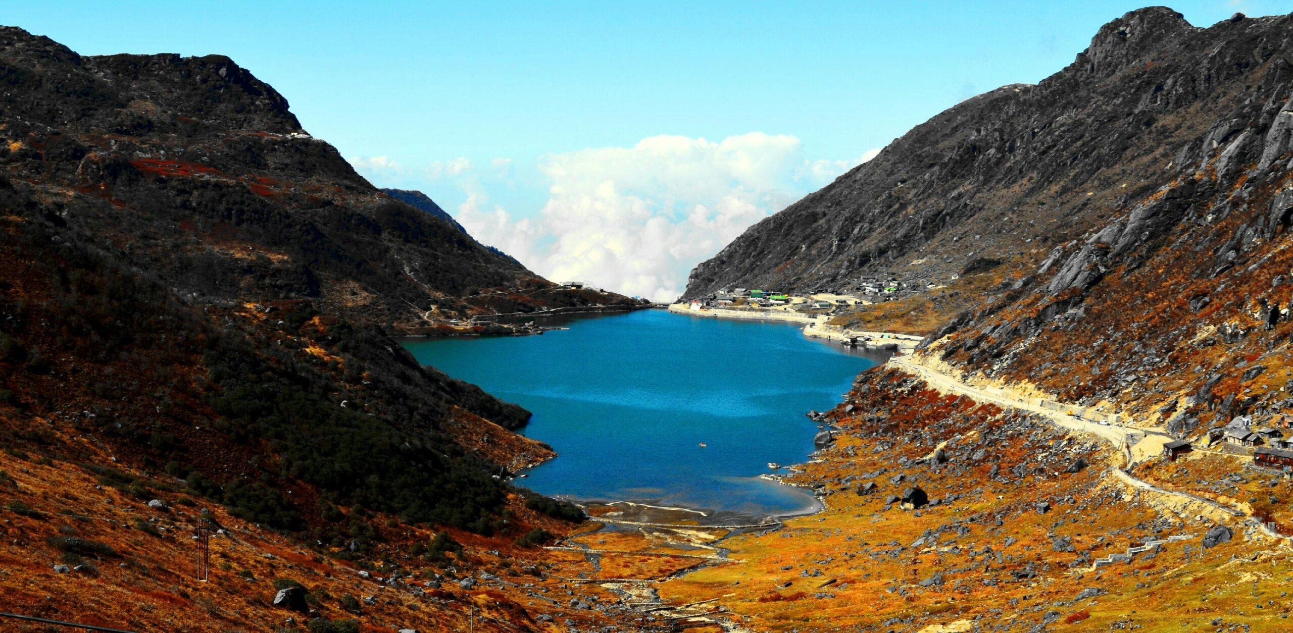 Stunning view of serene lake surrounded by rugged mountains in East Sikkim, India.